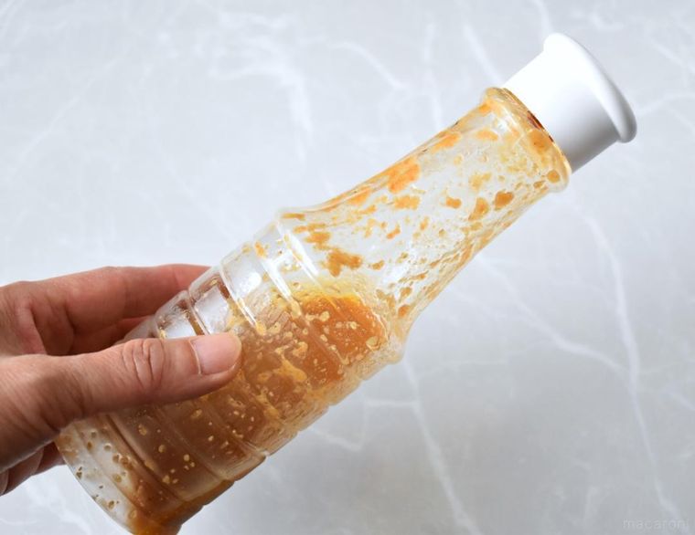 手に持ったドレッシングのボトル