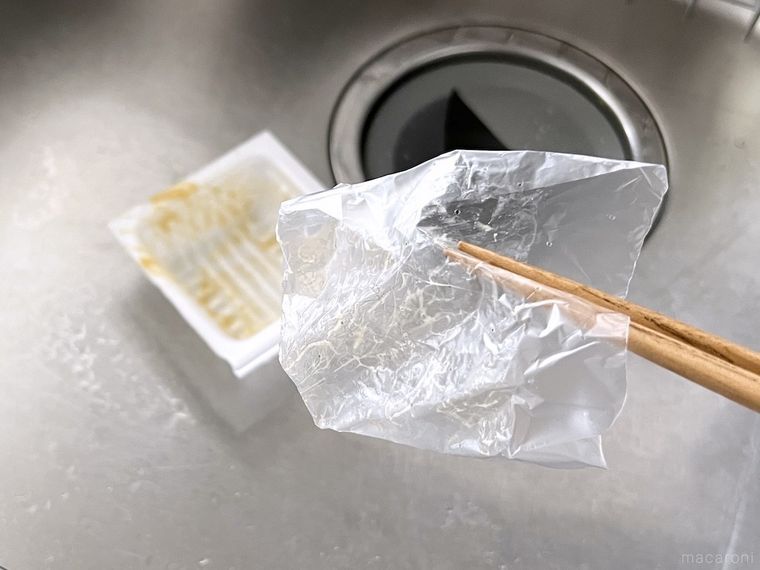 納豆のフィルムを箸で持ち上げている様子