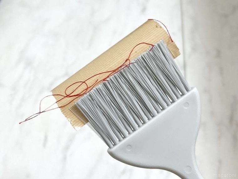 ガムテープを貼ったミニほうきで糸くずを掃除した様子