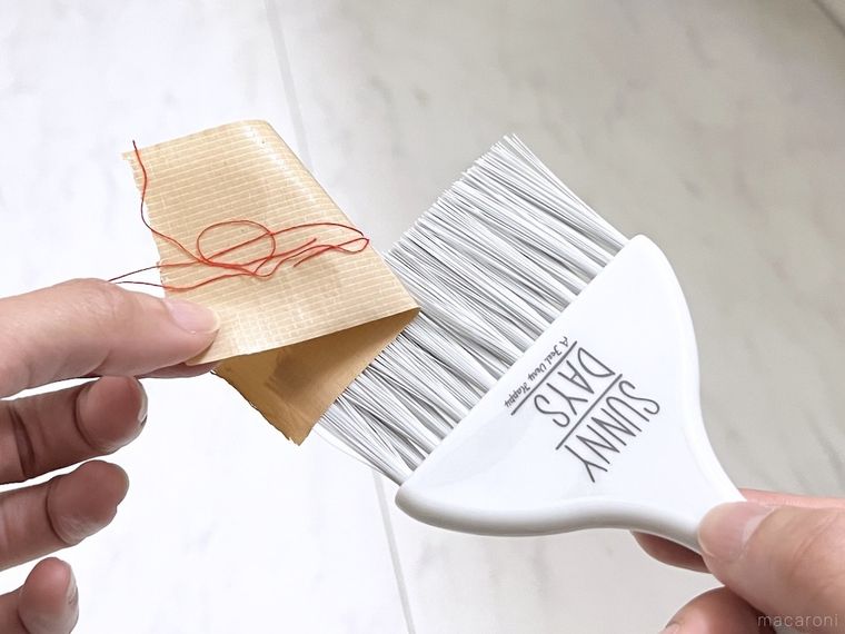 ミニほうきに付いたガムテープを剥がしている様子