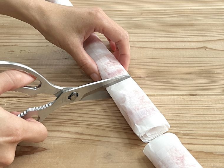 ベーコンを巻いたクッキングシートを切っている様子