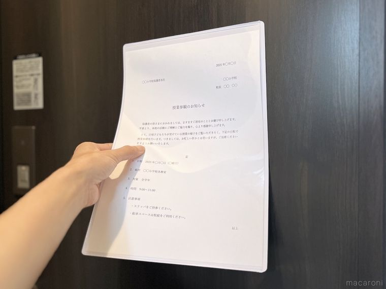 マグネット付きカードケースを玄関のドアに貼っている様子