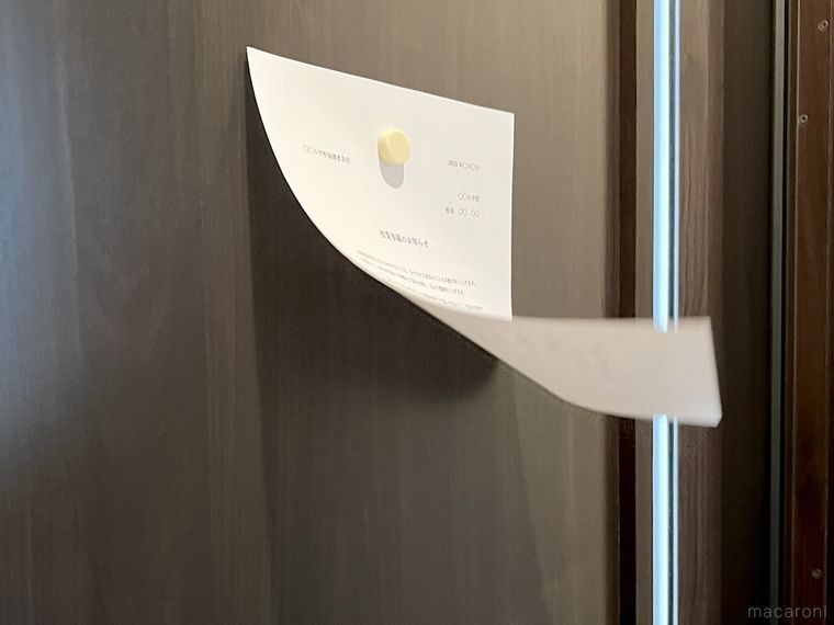 玄関のドアに貼ったプリントがめくれている様子