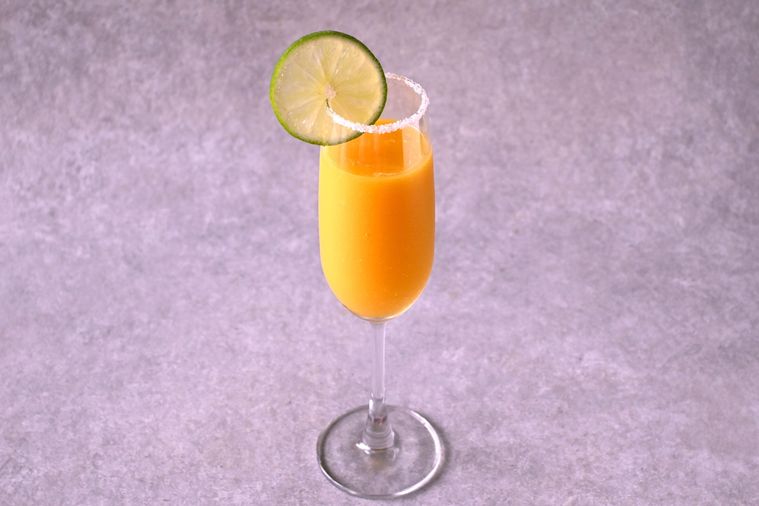 輪切りのライムが飾られたフローズンマンゴーオレンジのグラス