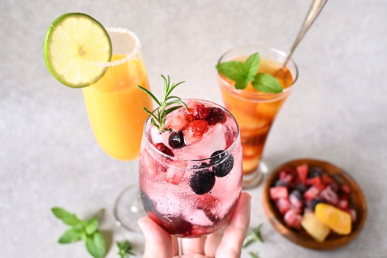 ミックスベリーソーダを入れたグラスを手で持つ様子