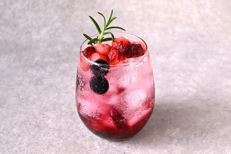 ミックスベリーソーダが入ったグラスにローズマリーが添えられている
