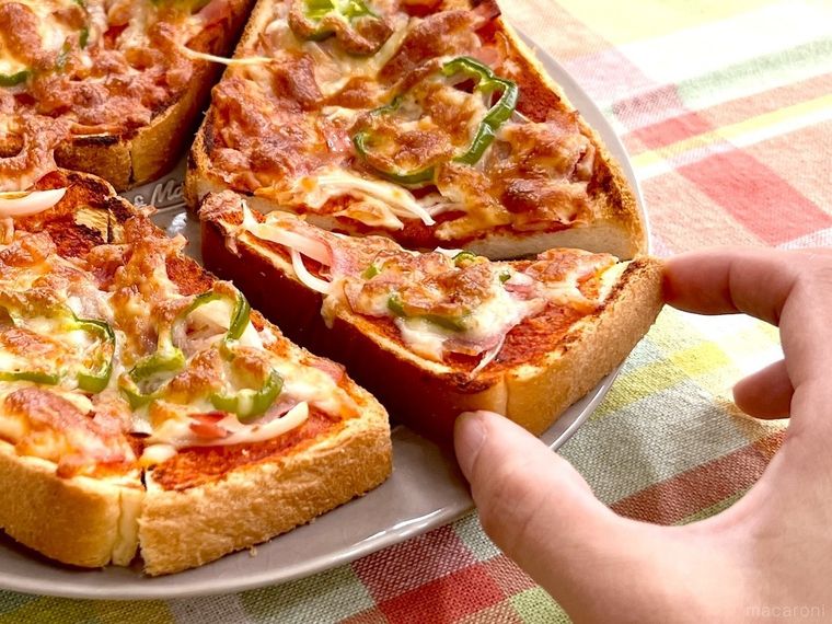 食パンピザを手で取っている様子