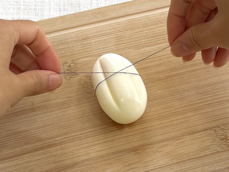 花型のゆで卵を糸で切っている様子
