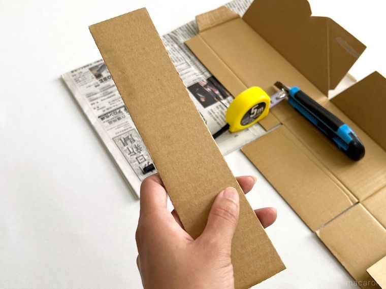 メジャーとカッターで段ボールを切った様子