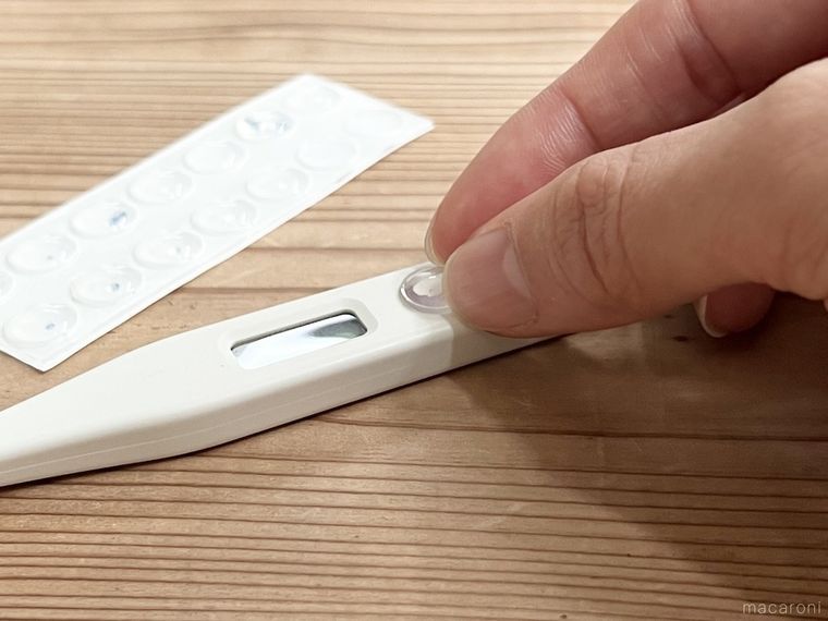 体温計のボタンにクッションゴムを貼っている様子