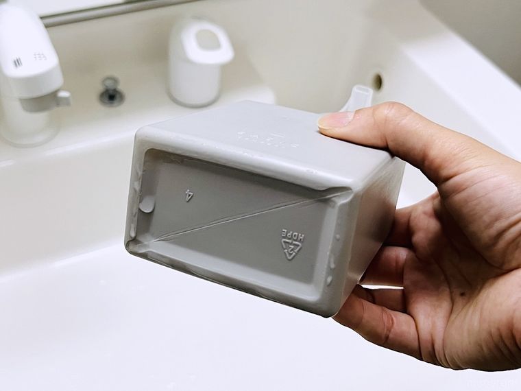 ハンドソープの容器を持ち上げている様子