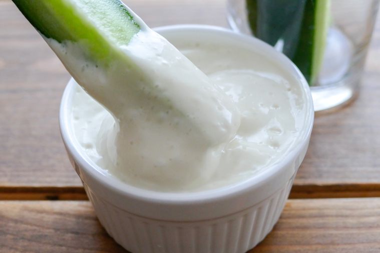 豆乳ヨーグルトマヨネーズにスティック状に切ったきゅうりをディップする様子