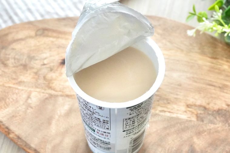 木のカッティングボードにのったジャスミン茶オレ入りのエメラルド色のカップの中身