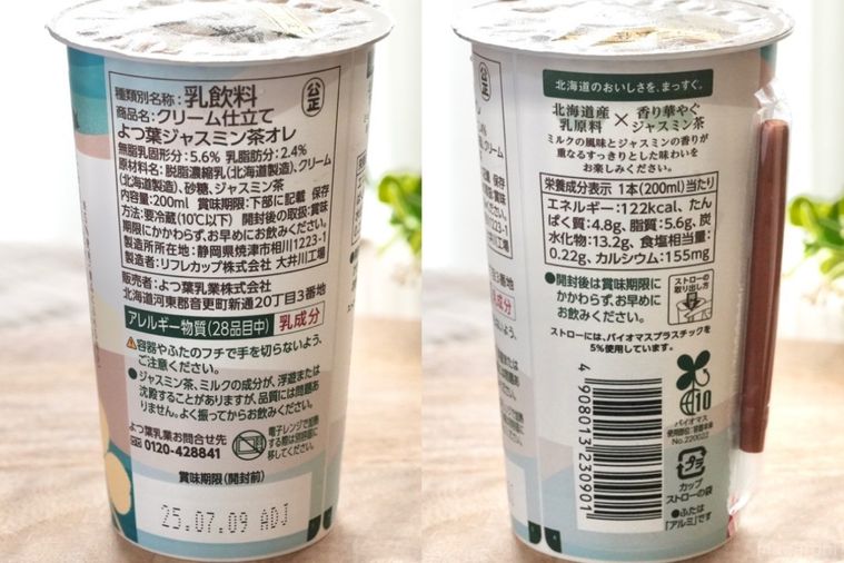 木のカッティングボードにのったジャスミン茶オレ入りのエメラルド色のカップの成分表示