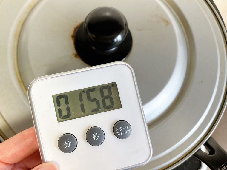 調理時間を計測しながらブロッコリーを炒める様子