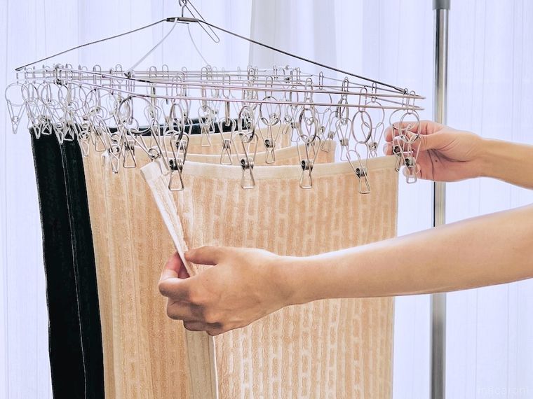 フェイスタオルをピンチハンガーから外している様子