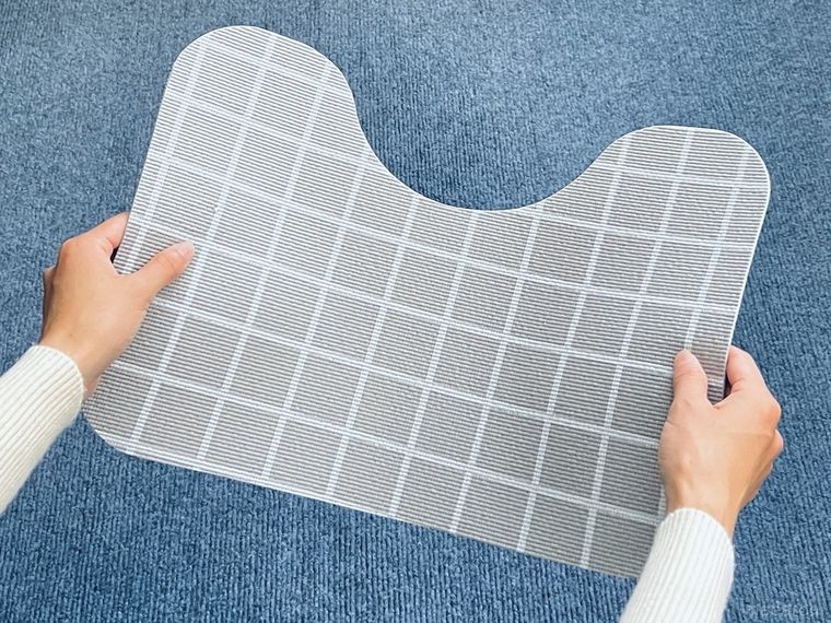 拭ける素材のトイレマットを手で持っている様子