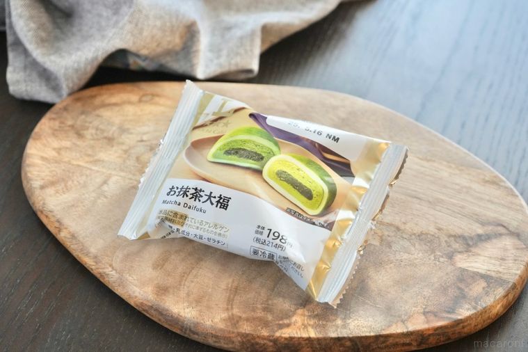 木のカッティングボードにのった抹茶大福のパッケージとグレーの布