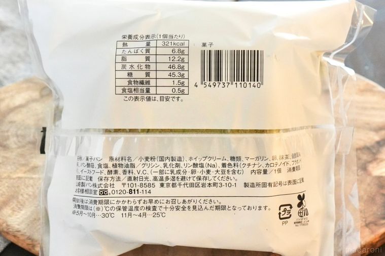 木のカッティングボードにのった抹茶とミルクホイップクリームサンドの菓子パンのパッケージの成分表示