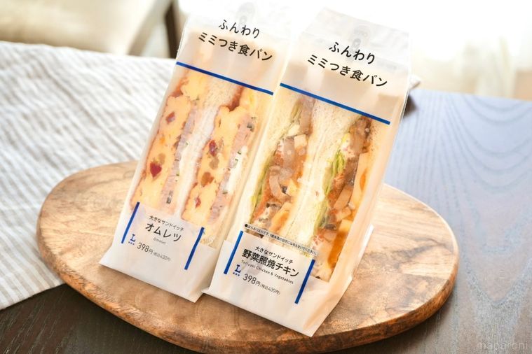 木のカッティングボードにのった2種類の耳付きサンドイッチとストライプの布