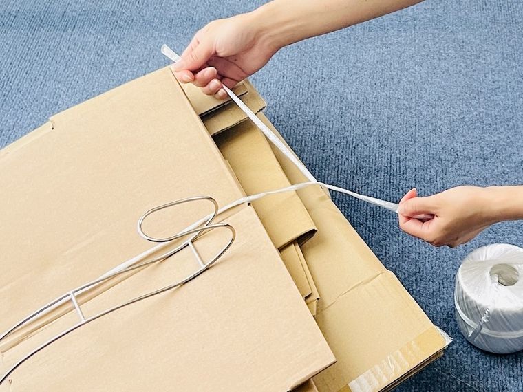ダンボールを紐で縛っている様子