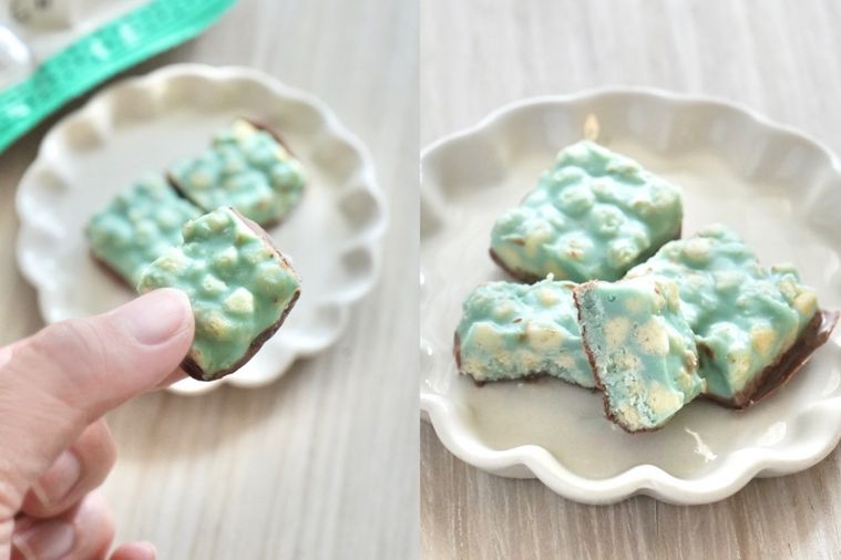 白いテーブルと白い小皿にのったチョコミント味のクランチチョコとパッケージの袋と手