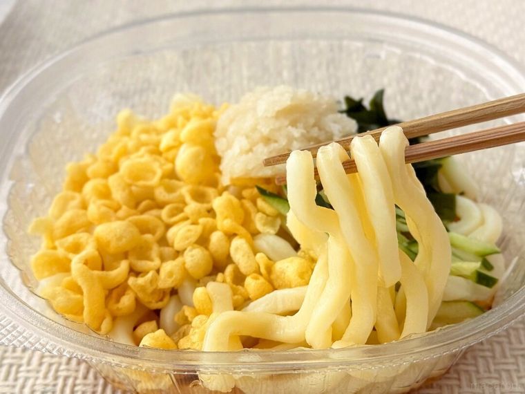 北海道産小麦の小麦粉使用 冷したぬきうどんの麺を箸で持っている様子