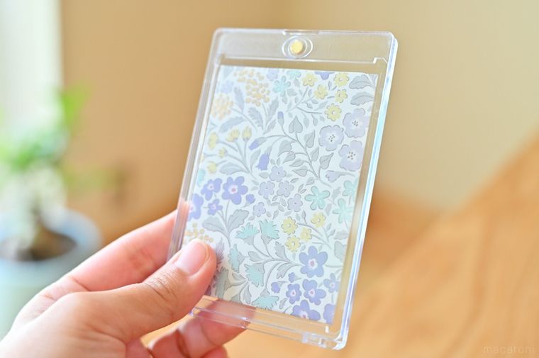 花柄の折り紙を入れた透明ケースを手に持っている