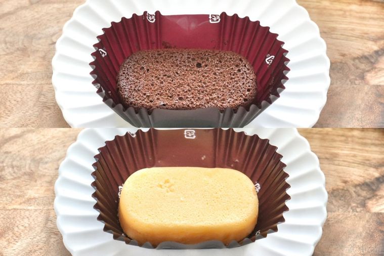 木のカッティングボードと白い皿と茶色いフィルムカップにのった泡食感のショコラケーキとチーズケーキ