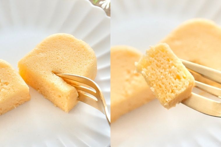 木のカッティングボードと白い皿にのった泡食感のチーズケーキの断面に金のフォークを刺して食べる様子とストライプの布とグリー