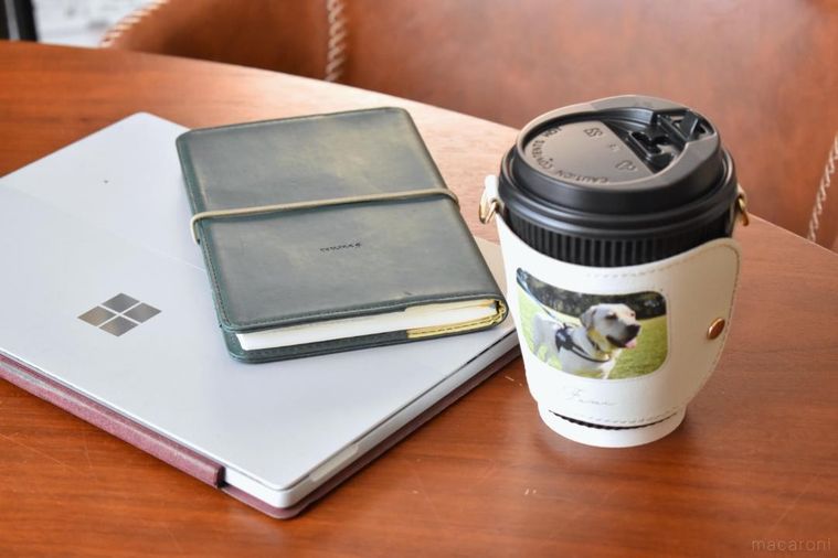 デスクの上に置いたカップホルダー、PC、ノート