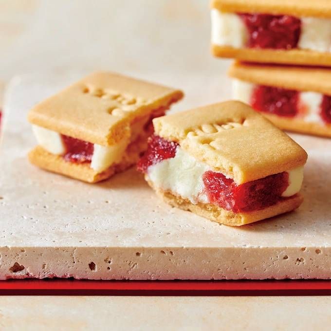 石でできた板の上に半分に割ったいちごミルクサンドとふたつを重ねたいちごミルクサンドが置かれている