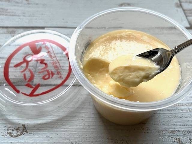 スプーンから落ちるとろみのあるプリン