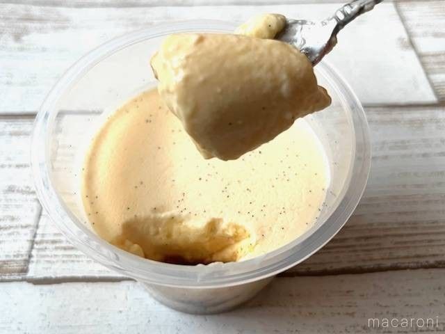 バニラビーンズ入りのプリンをカラメルソースと一緒にスプーンですくっている