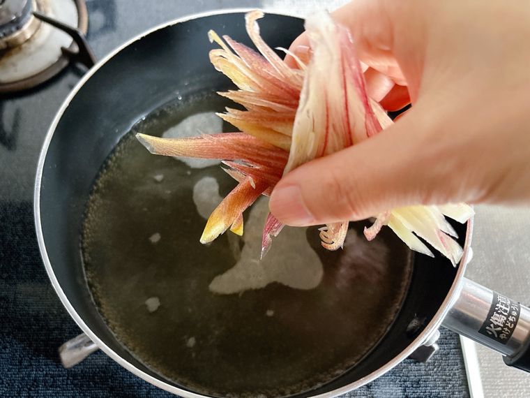 だし汁の火を止めてみょうがを入れる様子