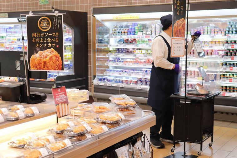 売り場で惣菜を売る様子