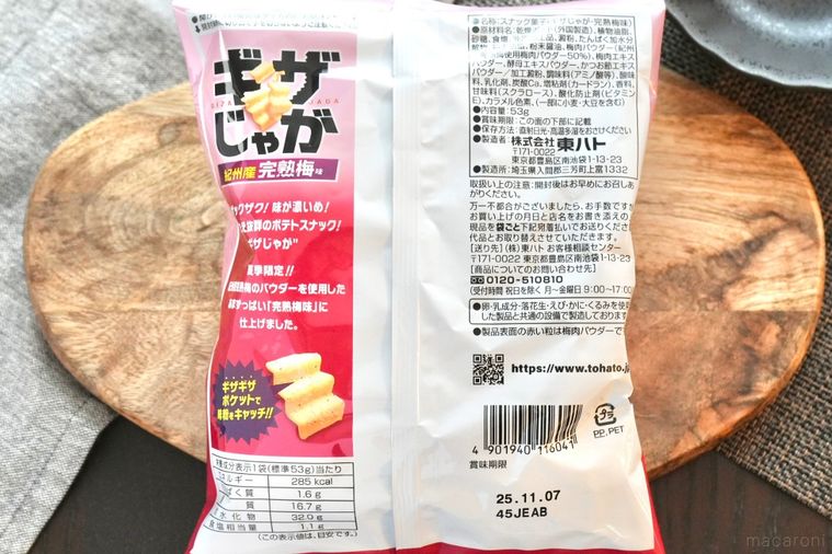 木のカッティングボードにのった梅味のポテトスナックとグレーの布と黒い器