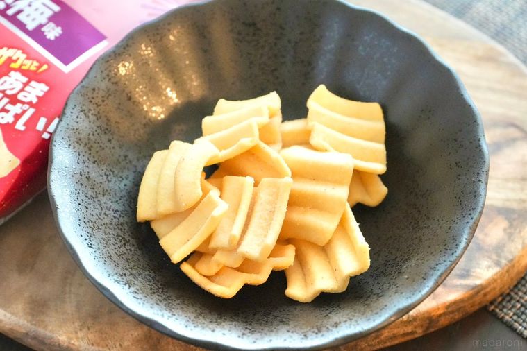 木のカッティングボードと黒い皿にのった梅味のポテトスナック