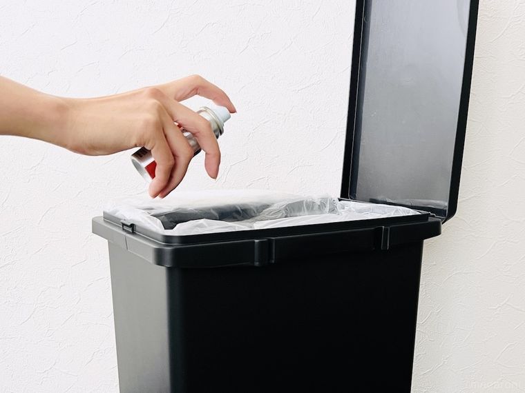 ごみ箱にコバエ駆除スプレーを噴射している様子