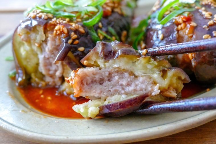 なすのはさみ焼きをひと口大に切って箸で持ち上げる様子