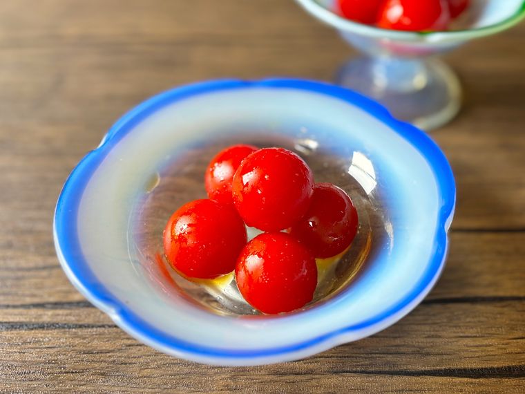 青色の縁取りのガラスの器に盛られたミニトマトのはちみつレモン漬け