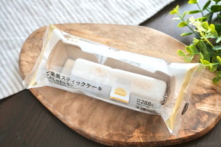 木のカッティングボードにのった白いレモン味のスティックケーキとストライプの布とグリーン