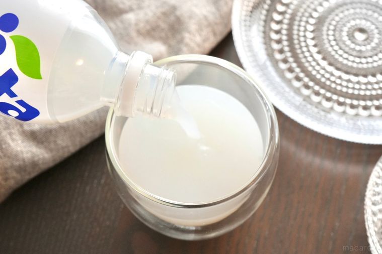 グラスにアンバサファンタをペットボトルから注ぐ様子とガラスの器とグレーの布