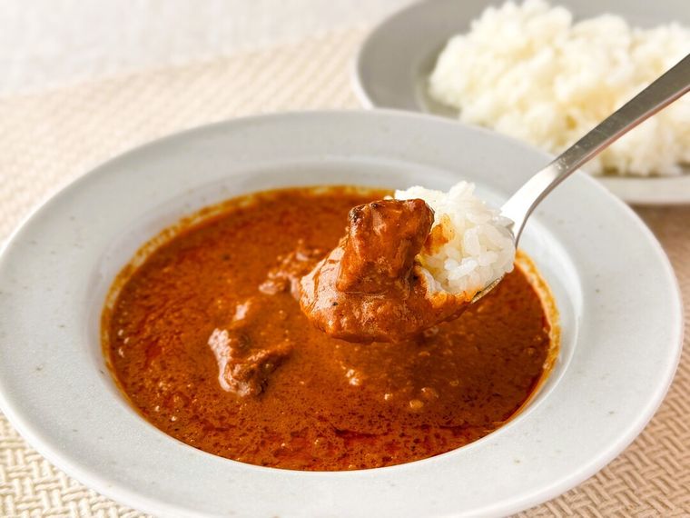 「現地に学ぶ インド ローストチキンのスパイシーカレー」をスプーンですくっている様子