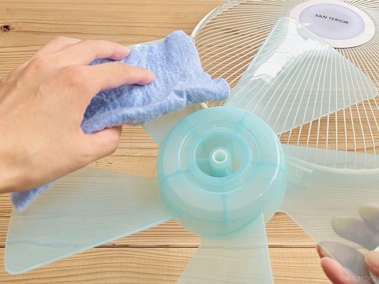 扇風機の羽根をクロスで拭いている様子