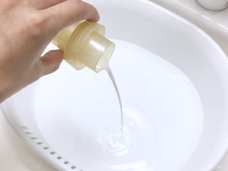 水が入った洗面器に柔軟剤を入れている様子