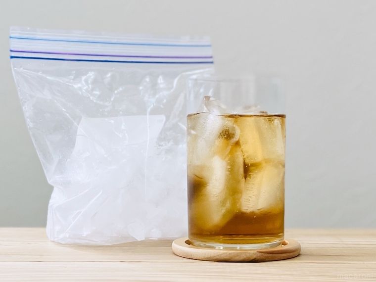 氷が入ったジッパー付き保存袋と麦茶が入ったグラス