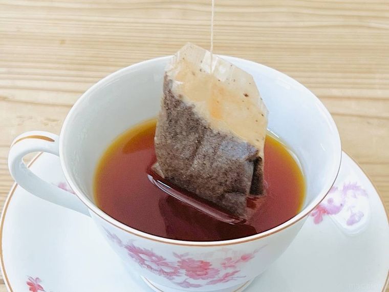 ティーカップからティーバッグを持ち上げている様子