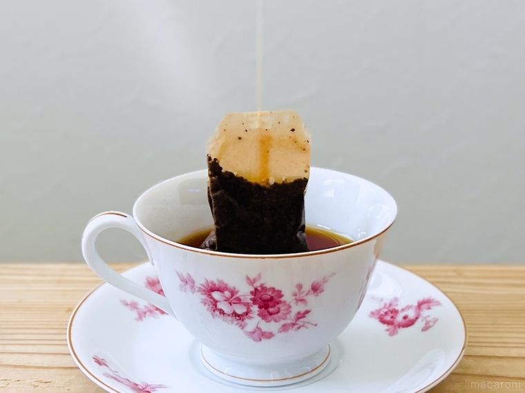 ティーカップからティーバッグを持ち上げている様子