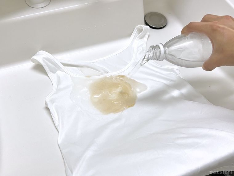 しょうゆがついた服に炭酸水をかけている様子